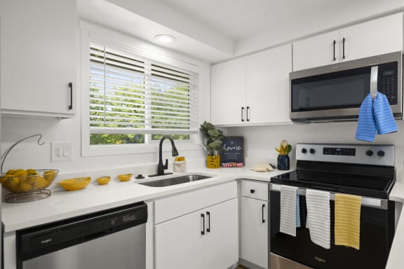 a kitchen with white cabinets and black appliances at Chalet, Springfield, Oregon