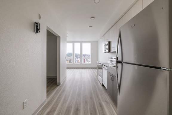 A modern kitchen with a refrigerator on the right side at Nook at Northaven Apartments, Seattle, Washington