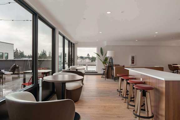 Elevation16 clubhouse  with wooden floors, floor to ceiling windows, a counter with bar stools