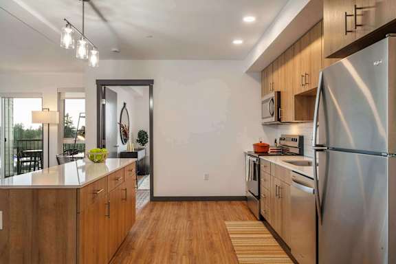 A modern kitchen with wooden cabinets and stainless steel appliances.