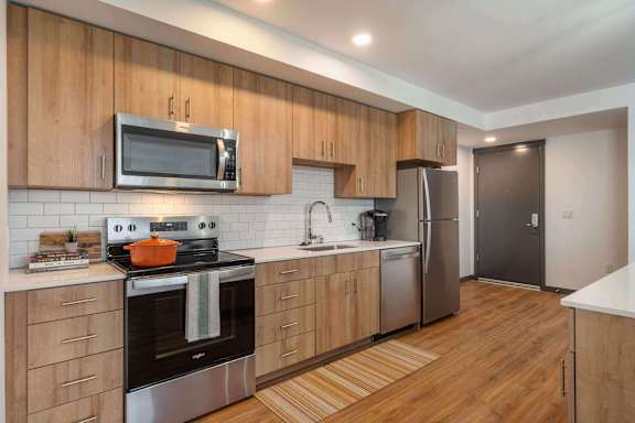 A modern kitchen with wooden cabinets and stainless steel appliances.
