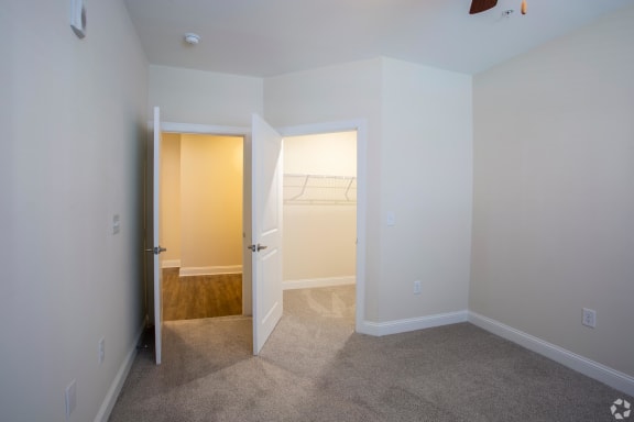 a bedroom with white walls and carpet  at The Retreat at Sixty-Eight Apartments, Greensboro, NC