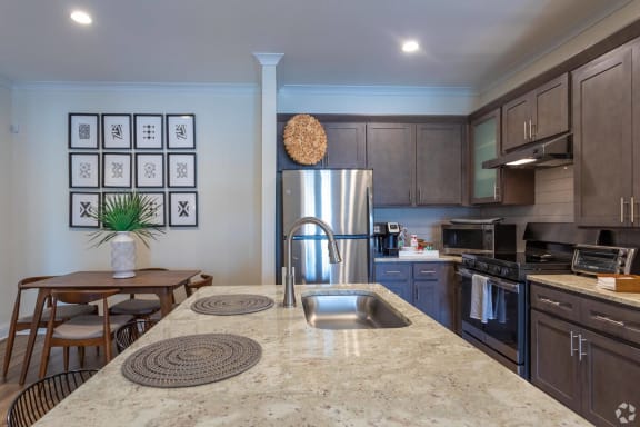 a kitchen with a large island and stainless steel appliances at Fuquay-Varina Apartments, North Carolina