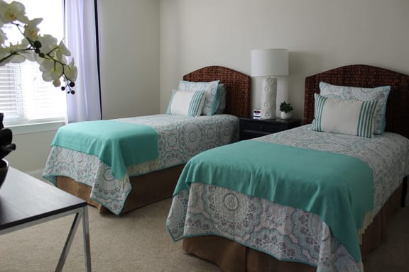 a bedroom with two beds and a table with a lamp at Sixty-Eight Apartments, Greensboro, 27409