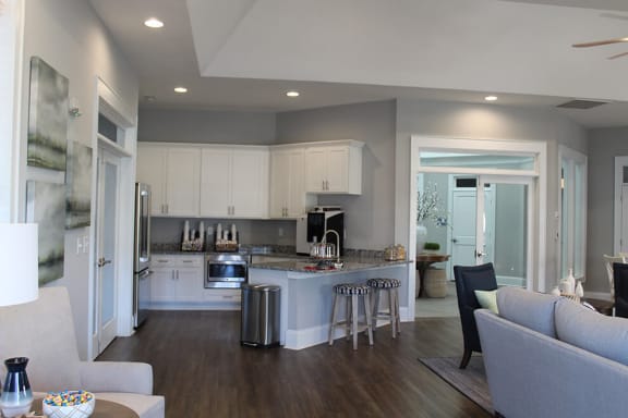 a kitchen with a center island next to a living room at The Retreat at Sixty-Eight Apartments, Greensboro, NC, 27409
