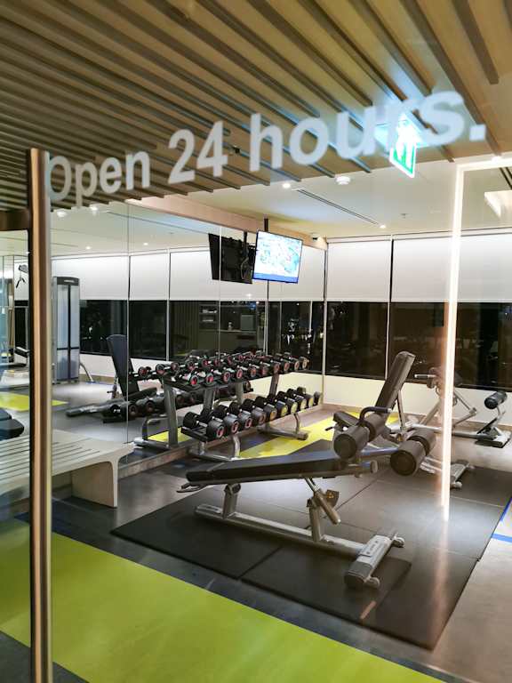 A gym with a sign that says open 24 hours.