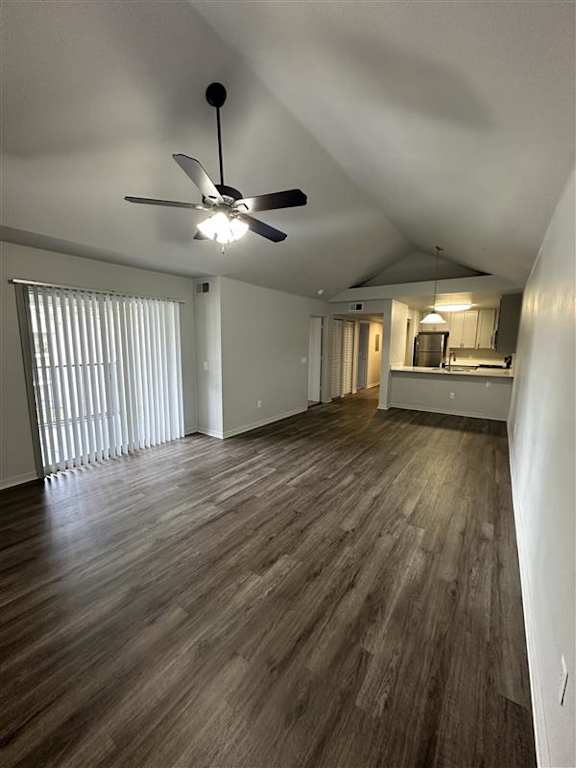 A room with a ceiling fan and wooden flooring.