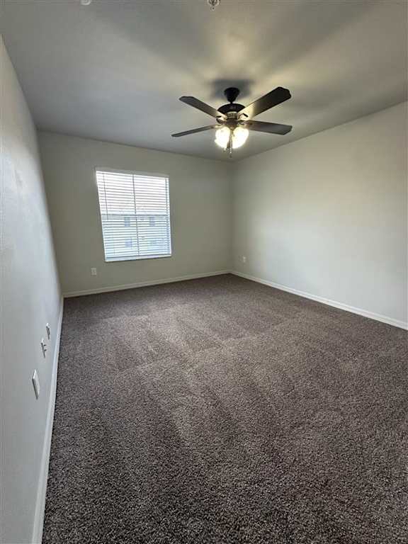 A room with a ceiling fan and carpeted floor.
