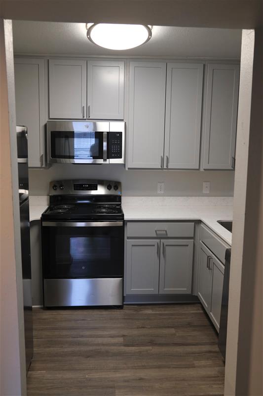A kitchen with a stove top oven and microwave above it.