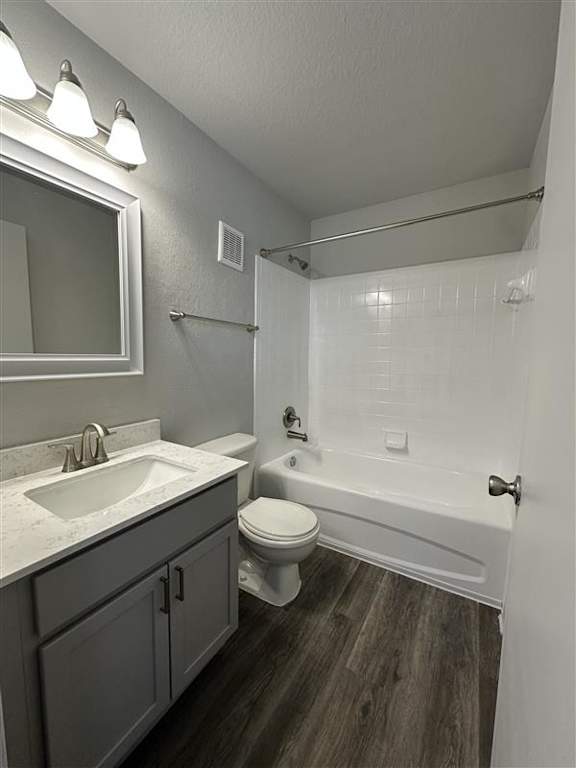 A bathroom with a white sink, toilet, and bathtub.