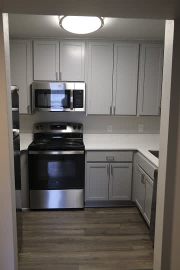 A kitchen with a stove top oven and microwave above it.