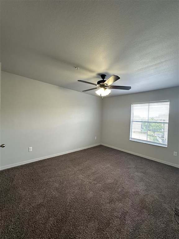 A room with a ceiling fan and carpeted floor.