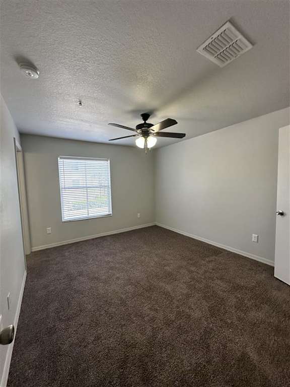 A room with a ceiling fan and carpeted floor.
