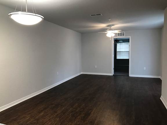 A room with a wooden floor and a ceiling fan.
