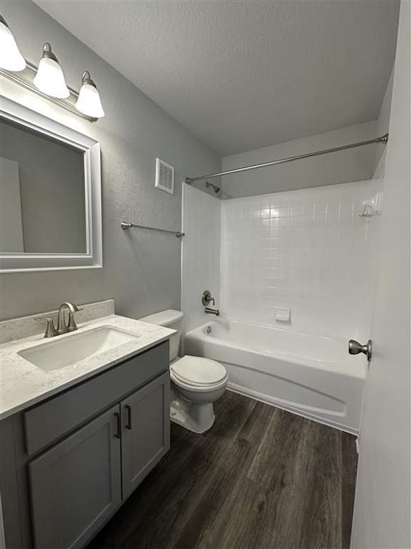 A bathroom with a white sink, toilet, and bathtub.