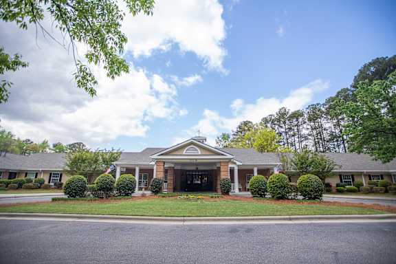 A building with a green lawn in front.at Spring Arbor of Wilson, Wilson, NC