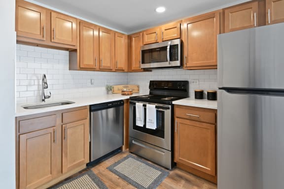 Kitchen with wood cabinets and stainless appliances at Fox Run Apartments, St. Charles