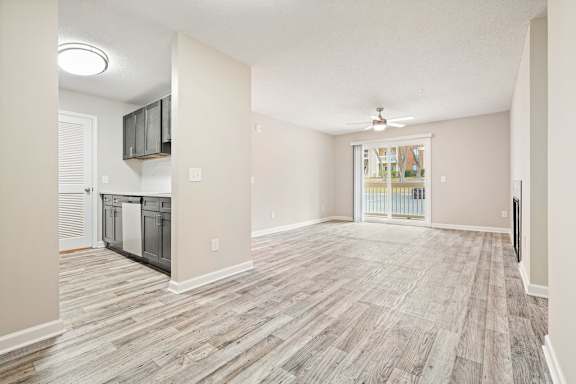 A spacious room with wood flooring and a ceiling fan.