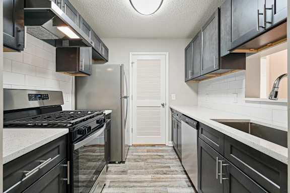 A kitchen with black cabinets and stainless steel appliances.