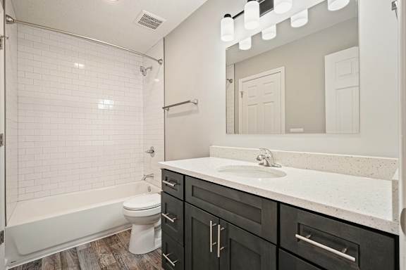 A white bathroom with a black vanity and a white tub.