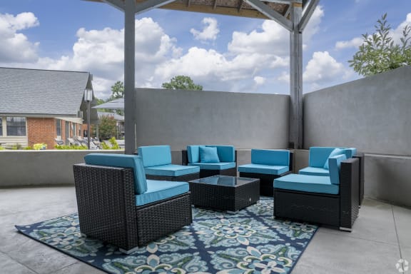 an outdoor patio with blue chairs and a coffee table