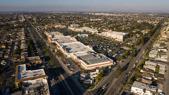 A parking lot is surrounded by buildings and roads.