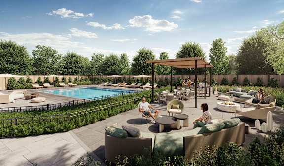 A poolside area with people sitting and enjoying the sun.