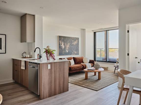 A modern kitchen with wooden cabinets and a large window.