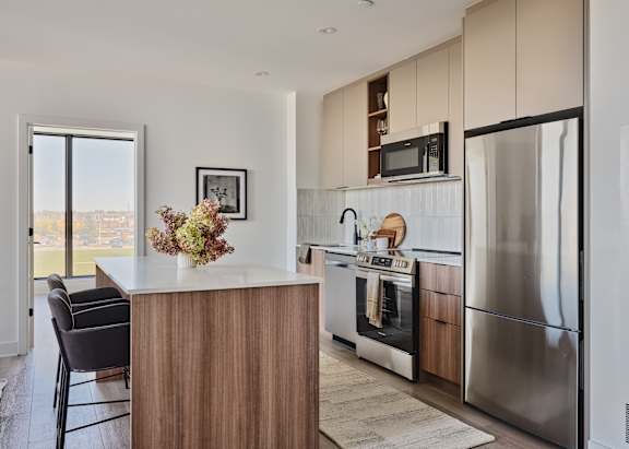 A modern kitchen with a wooden island and stainless steel appliances.