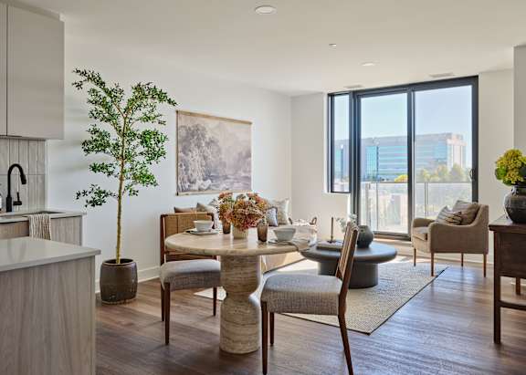 A modern dining room with a table set for two and a view of the city.