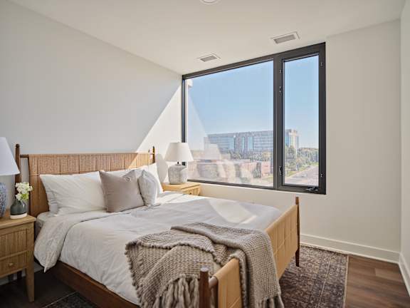 A bedroom with a large bed and a view of the city.