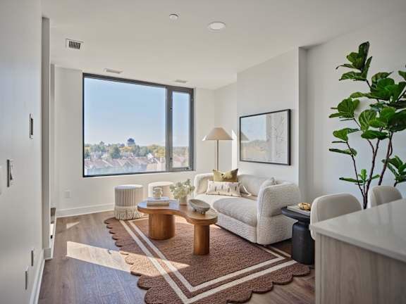 A living room with a large window overlooking a cityscape.