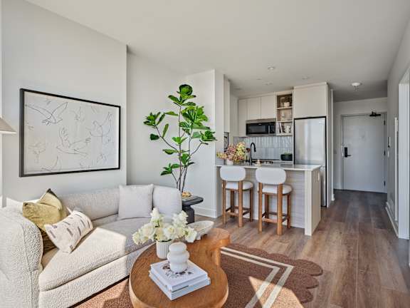 A living room with a couch, a coffee table, and a painting on the wall.