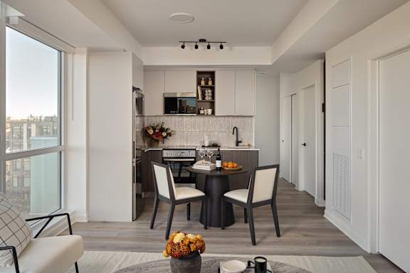 A modern kitchen with a dining table set for two.