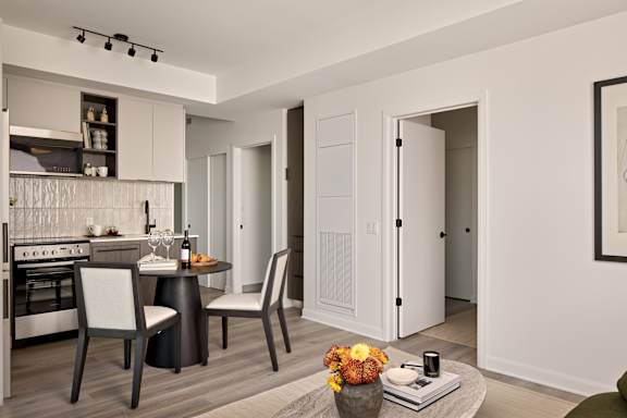 A modern kitchen with a dining table set for two.
