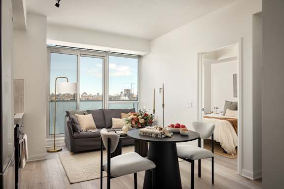 A modern dining room with a table set for four and a view of the city.