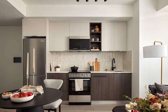 A modern kitchen with a refrigerator, oven, and sink.