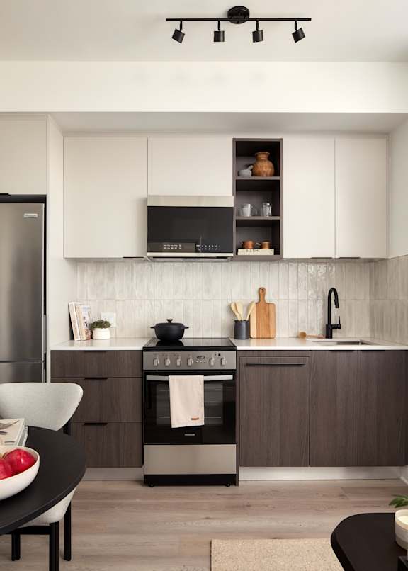 A modern kitchen with a black oven and white cabinets.
