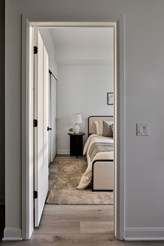 A bedroom with a bed, nightstand, and lamp.