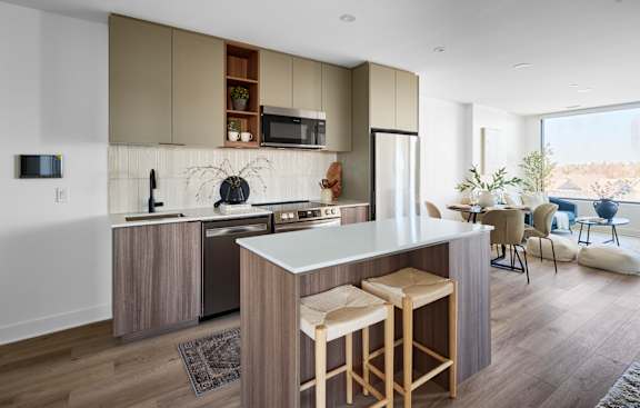 A modern kitchen with a bar stool in front of the island.