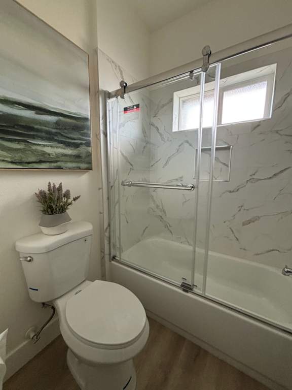 A white toilet sits next to a walk-in shower.