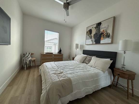 A bedroom with a large bed and a painting on the wall.