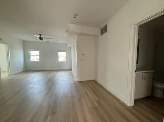 A room with wooden floors and a ceiling fan.