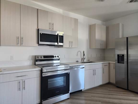 A modern kitchen with stainless steel appliances and white cabinets.