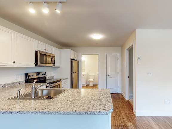 Kitchen island with granite countertop and bathroom view at Autumn Woods Apartments, Westbrook, ME 04092