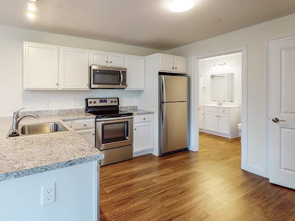 Kitchen with stainless steel appliances and granite countertops at Autumn Woods Apartments, Westbrook, ME