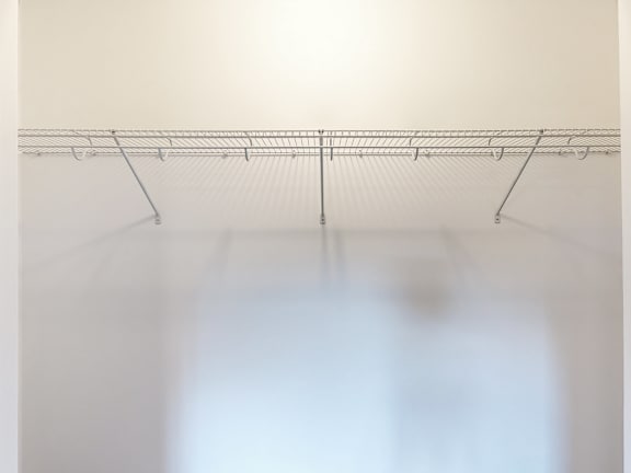 Wire shelving with hanging rod storage solution at Autumn Woods Apartments, Maine