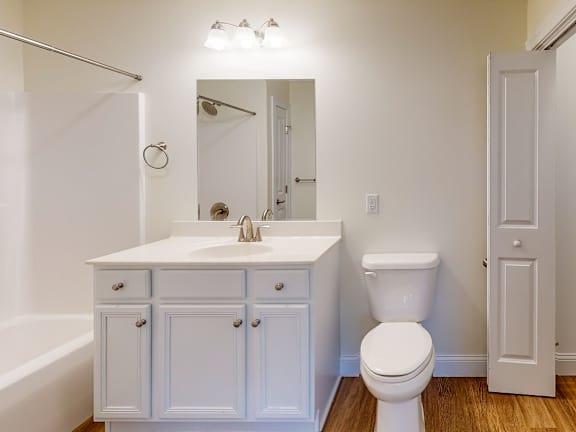 Bright bathroom with vanity mirror and wood floors at Autumn Woods Apartments, Maine, 04092