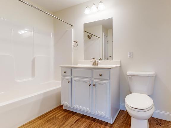 Bathroom with gray vanity and wood style flooring at Autumn Woods Apartments, Westbrook, ME 04092