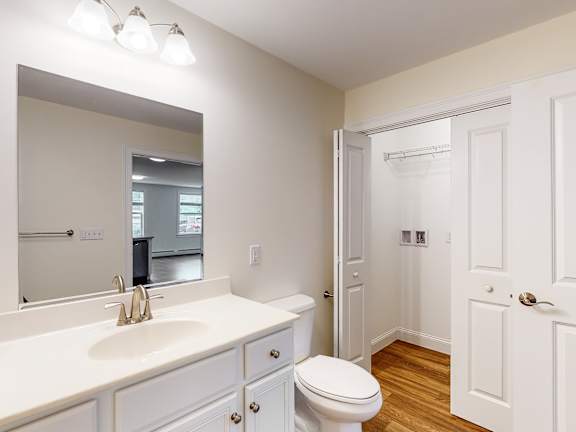Bathroom with white vanity and walk-in closet at Autumn Woods Apartments, Westbrook, Maine